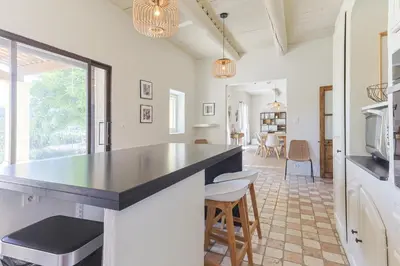 a kitchen with a counter and chairs in a room at Villa Vue Luberon in Gordes
