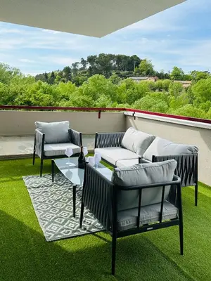 a patio with couches and a table on the grass at 10 mn gare TGV Aix, parking gratuit & check-in autonome in Aix-en-Provence