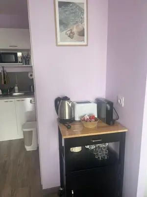 a kitchen with a table with a microwave and a sink at Studio cosy, résidence de tourisme avec piscine in Aix-en-Provence