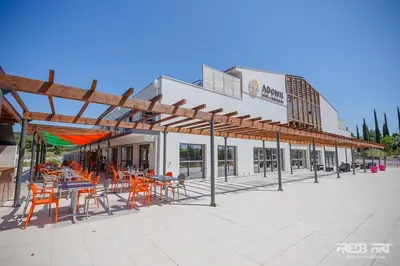 a patio with tables and chairs in front of a building at Studio cosy, résidence de tourisme avec piscine in Aix-en-Provence