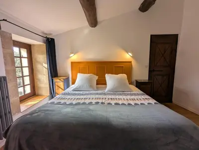 a bedroom with a large bed with two pillows at Mas traditionnel à Gordes en pleine nature in Gordes