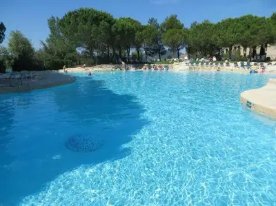 a large pool of blue water with people on a beach at SUNRISE - Golf de Pont Royal in Mallemort