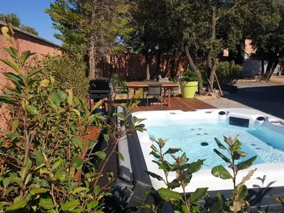 a swimming pool in a backyard with a table and chairs at Logement indépendant avec Jacuzi pour 4ou 5 personnes, 2 chambres in Aureille