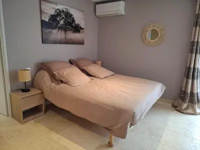 a bed in a bedroom with a lamp on a table at Logement indépendant avec Jacuzi pour 4ou 5 personnes, 2 chambres in Aureille