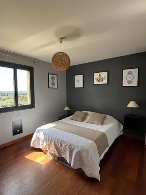 a bedroom with a large bed and two windows at Villa Aix-en-Provence Pool and absolute calm in Aix-en-Provence