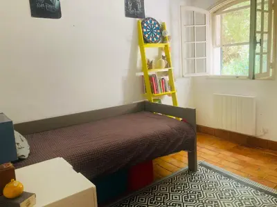 a bedroom with a bed and a book shelf at Maison de famille en Provence in Rognes