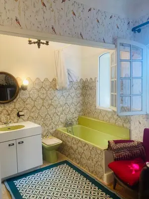 a bathroom with a green tub and a toilet and a sink at Maison de famille en Provence in Rognes