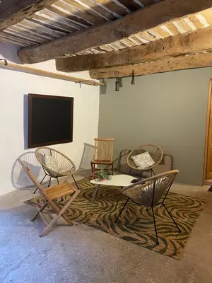 a living room with chairs and a flat screen tv at Room in Medieval Cereste in Céreste