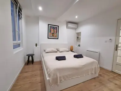 a white bedroom with a white bed with two pillows on it at Appartement climatisation centre historique in Aix-en-Provence