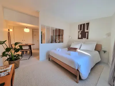 a bedroom with a large white bed and a table at MAYU MAYU - cocon centre-ville climatisation in Aix-en-Provence