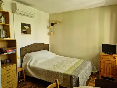 a bedroom with a bed and a dresser and a television at Maisonnette de charme dans domaine naturiste au pied du Mont Ventoux ! in Bédoin