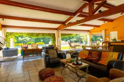 a large living room with couches and a table at Le Mas des lys - Guest houses au coeur de la Provence dans un parc paysagé avec piscine, sauna et boulodrome in Grans