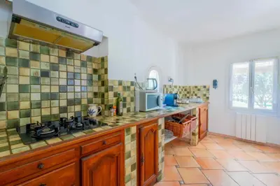 a kitchen with a sink and a stove in it at Le Mas des lys - Guest houses au coeur de la Provence dans un parc paysagé avec piscine, sauna et boulodrome in Grans