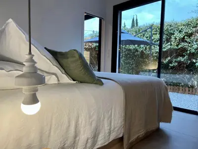 a bedroom with a white bed and a window at La Réserve Villa in Aix-en-Provence