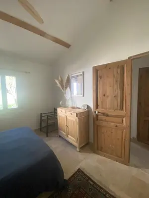 a bedroom with a bed and a wooden cabinet at Villa Augustine in Ventabren
