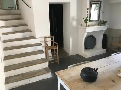 a room with stairs and a table and a fireplace at La Grande Bastide in Vaugines
