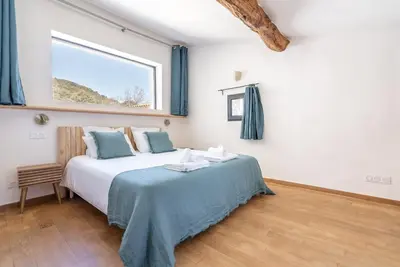 a bedroom with a large bed with a window at Evasion Luberon in Murs