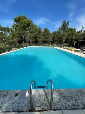 a large swimming pool with blue water at Gîte 33 ha Piscine Activités Vue in Saumane-de-Vaucluse