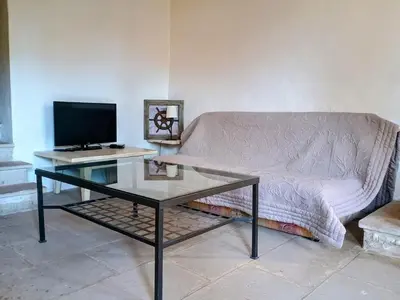 a living room with a couch and a glass table at Gîte 33 ha Piscine Activités Vue in Saumane-de-Vaucluse