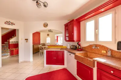a kitchen with red cabinets and a red rug at Universo private pool and large garden in Pernes-les-Fontaines