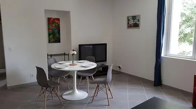 a dining room with a table and chairs and a tv at GitesLuberon 2 F2 in Charleval