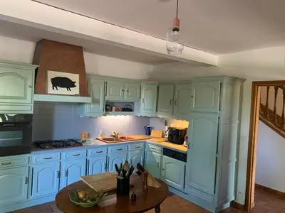 a kitchen with blue cabinets and a table at Villa CHATEAU SAINTE BARBE in Loriol-du-Comtat