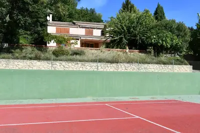 a tennis court with a tennis ballphasis at Villa CHATEAU SAINTE BARBE in Loriol-du-Comtat