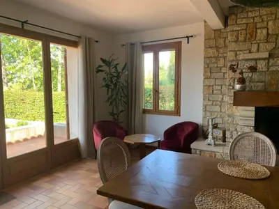 a dining room with a table and chairs and a window at Villa CHATEAU SAINTE BARBE in Loriol-du-Comtat