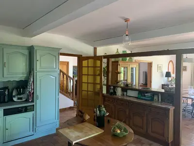 a kitchen with blue cabinets and a table at Villa CHATEAU SAINTE BARBE in Loriol-du-Comtat