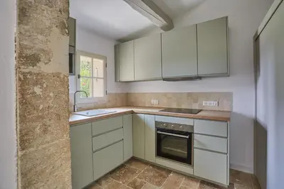 a kitchen with white cabinets and a sink at Bastide entièrement rénovée au coeur de Goult in Goult