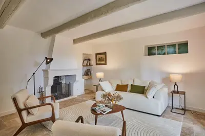 a living room with a white couch and a fireplace at Bastide entièrement rénovée au coeur de Goult in Goult
