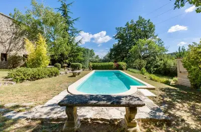 a swimming pool in a yard with a stone bench at Maison de James in Murs