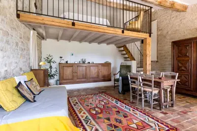 a living room with a couch and a dining room at Maison de James in Murs