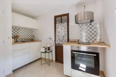 a kitchen with white cabinets and a stove top oven at Maison de James in Murs