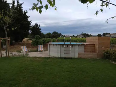 a building with a trampoline and two chairs in a yard at Gîte le Micocoulier in Carpentras