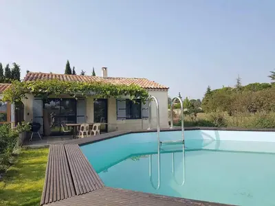 a swimming pool in front of a house at Gîte le Micocoulier in Carpentras