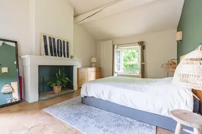 a bedroom with a bed and a fireplace at Mas provençal, entre vignes et oliviers in Lambesc