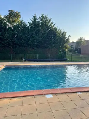 a swimming pool with blue water in a yard at Évasion Provençale in Aix-en-Provence