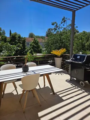 a table and chairs on a patio with a grill at Évasion Provençale in Aix-en-Provence