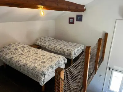 a room with two beds in a room at Gîte The Butterfly - 1 bedroom and mezzanine in Monteux