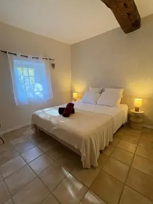 a bedroom with a large white bed with two lamps at Les 2 voûtes - Mas provençal pour 10 personnes in Oppède