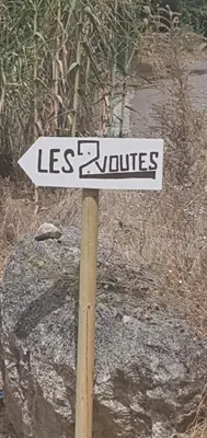 a sign that says less squares on a wooden pole at Les 2 voûtes - Mas provençal pour 10 personnes in Oppède