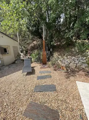 a garden with a chair and a large vase at Villa climatisée avec piscine in Gordes