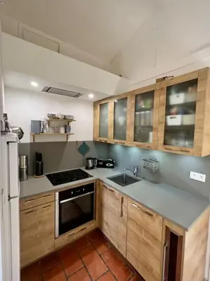 a kitchen with wooden cabinets and a stove top oven at Villa climatisée avec piscine in Gordes