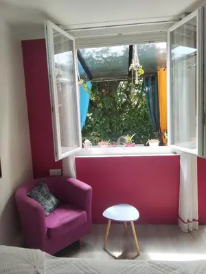 a living room with a purple couch and a window at Chez Nine, chambre indépendante avec terrasse in Sénas
