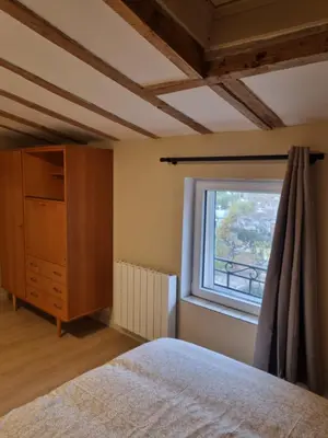 a bedroom with a bed and a window at La maison du quai in LʼIsle-sur-la-Sorgue