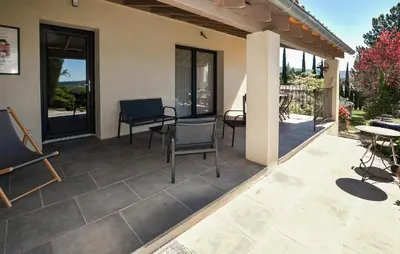 a patio with chairs and tables and windows at Baumann 1 in Bédoin
