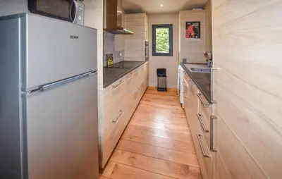 a kitchen with a refrigerator and wooden floors at Baumann 1 in Bédoin