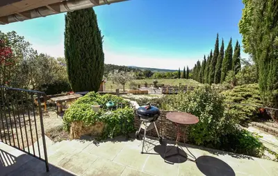 a patio with a table and chairs in a garden at Baumann 1 in Bédoin