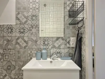 a bathroom with a white sink and a mirror at Renovated 2-room apartment in historic center in Aix-en-Provence